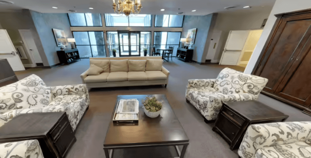 A modern lobby featuring comfortable seating with a sofa and two chairs around a stylish coffee table.