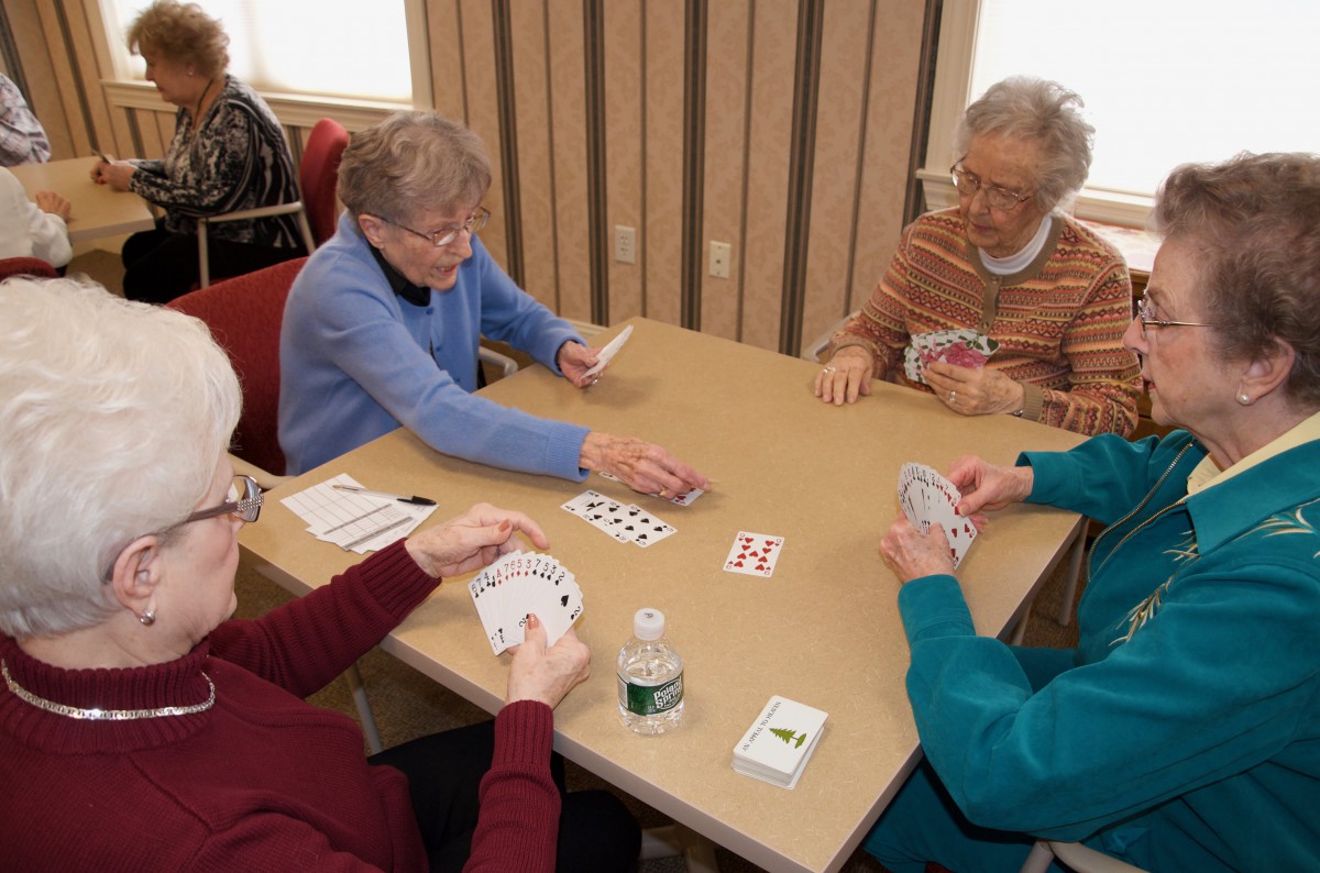 A group of seniors enjoying a card game together indoors.