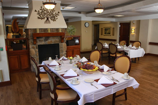 A beautifully arranged dining room showcasing an inviting table setting and a warm fireplace.