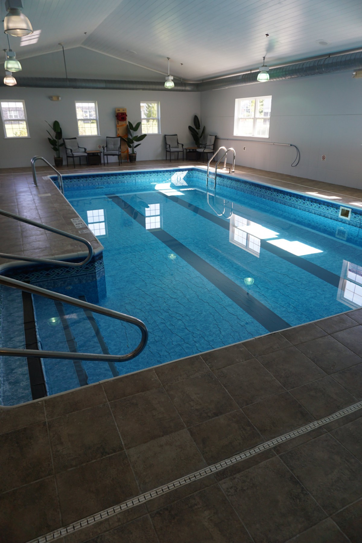 An indoor swimming pool with clear water and surrounding tiles.