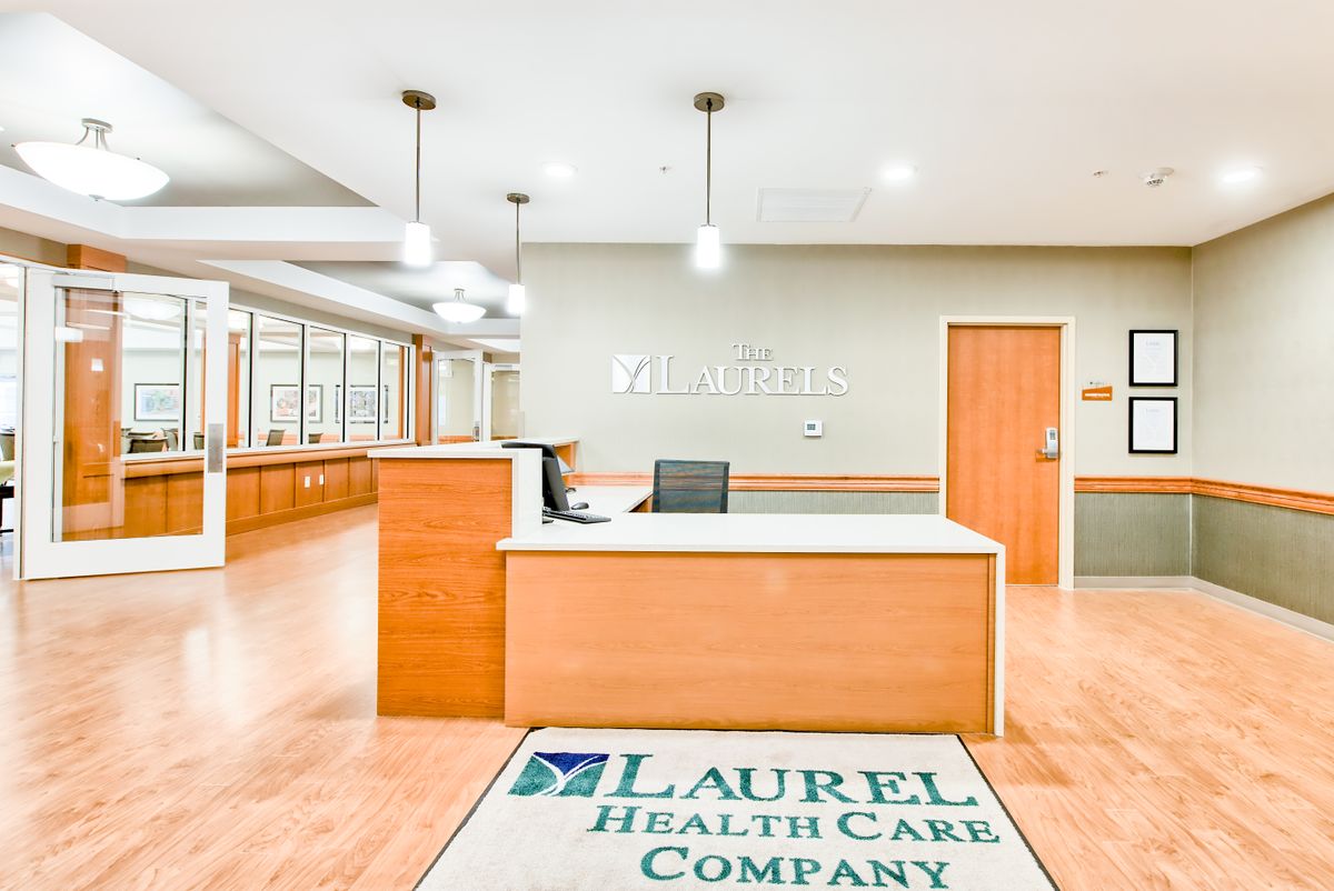 A modern healthcare reception area with a wooden desk and bright lighting.