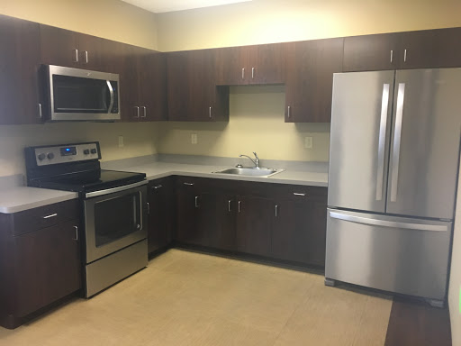 A modern kitchen featuring stainless steel appliances and dark wood cabinets.