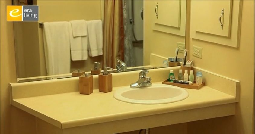 A clean bathroom sink with toiletries and towels neatly arranged.
