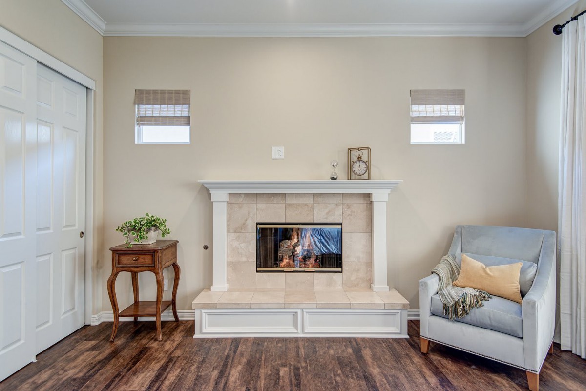 A cozy living room featuring a central fireplace, wooden floors, and elegant decor.