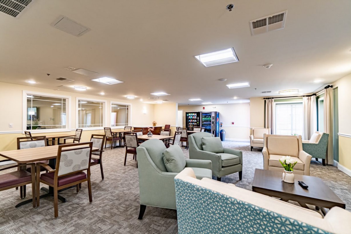 A spacious and bright lounge area with comfortable seating and tables.