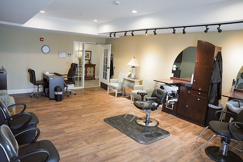 An empty hair salon with stylish furniture and wooden flooring.