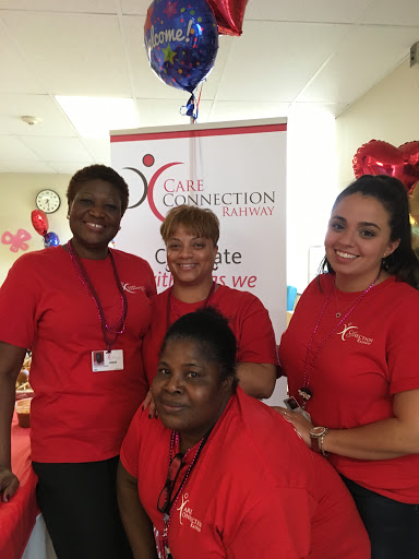 A joyful group of women celebrating an event together, all wearing matching red shirts.