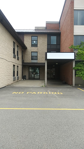 A view of a building entrance with a clear 'No Parking' sign painted on the ground.