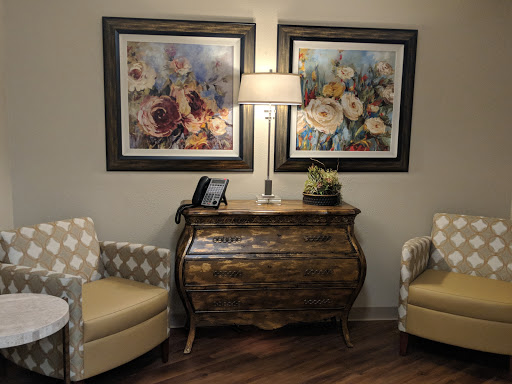 A cozy living room setup featuring elegant artwork, a stylish lamp, and comfortable seating.