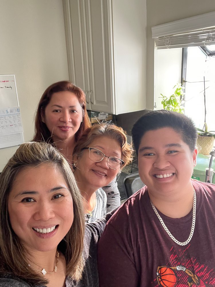 A group of people smiling together in a kitchen.