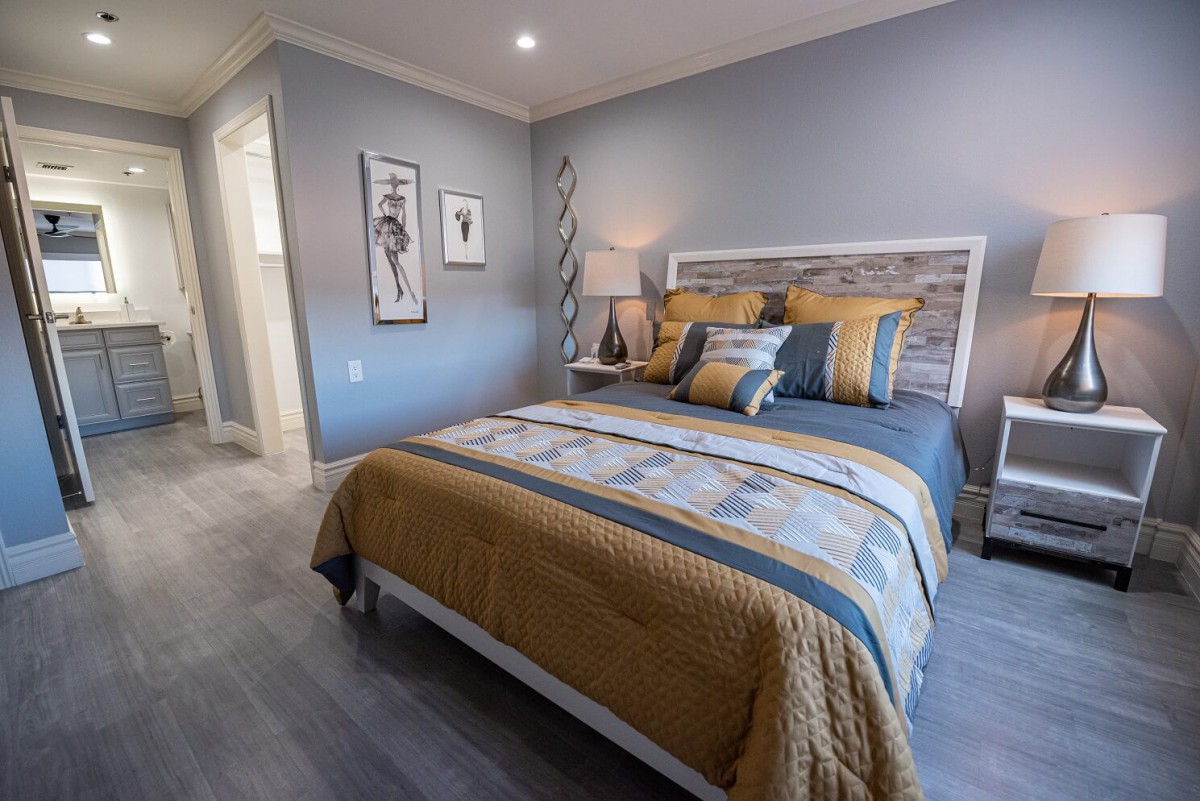 A modern bedroom with a stylish bed, cozy decor, and contemporary artwork on the walls.