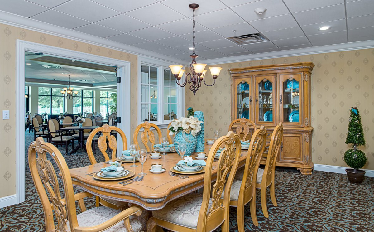 A well-appointed dining room with a wooden table, elegant place settings, and a decorative china cabinet.