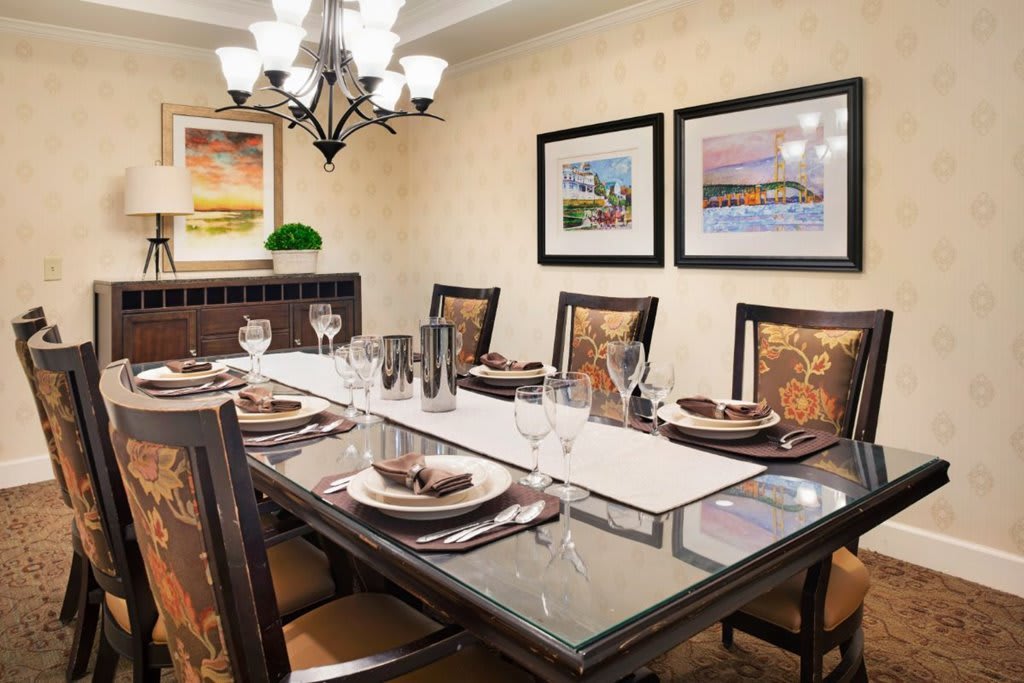 An elegant dining room with a beautifully set table and tasteful artwork on the walls.
