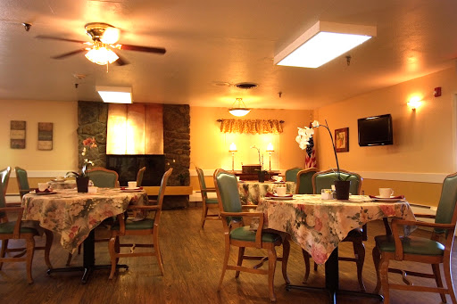 A cozy dining area featuring tables and chairs, illuminated by warm lighting.