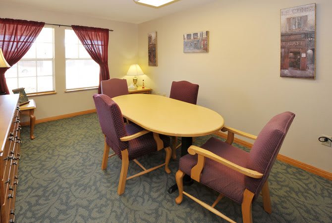 A meeting room with a conference table, chairs, and a lamp by the window.
