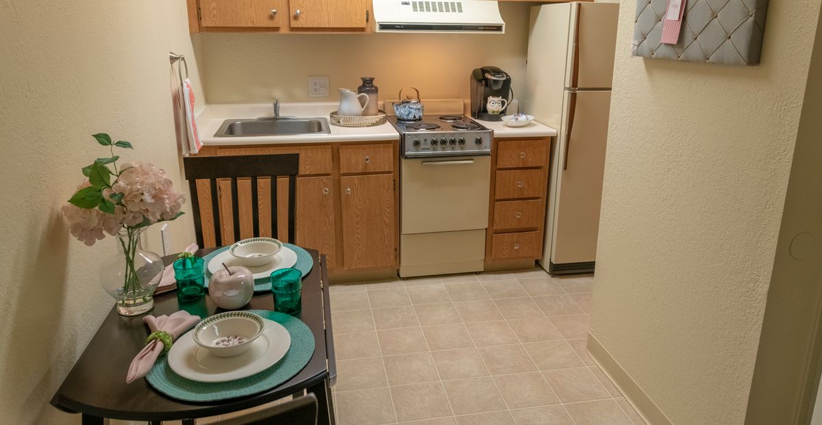 Cozy apartment kitchen with dining area and basic appliances.