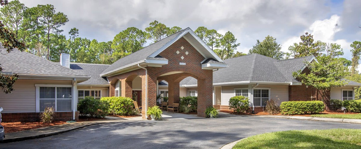 A brick building with a covered entrance and well-maintained landscaping.