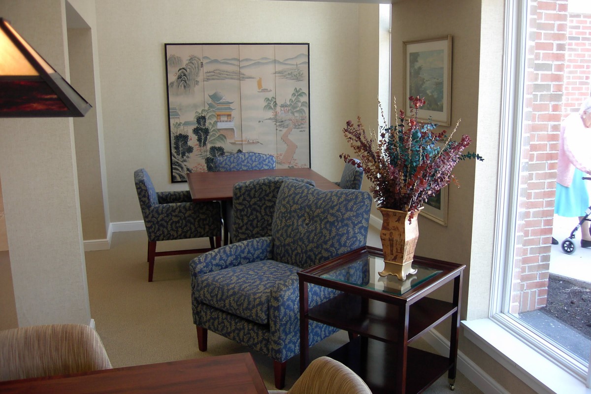 An office space with comfortable seating, artwork on the walls, and a decorative plant.