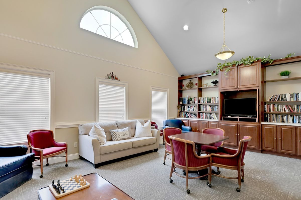 A cozy living room with a vaulted ceiling, featuring comfortable seating and a chessboard on the coffee table.