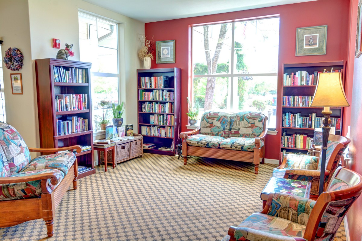 A cozy library reading area with bookshelves and comfortable seating.
