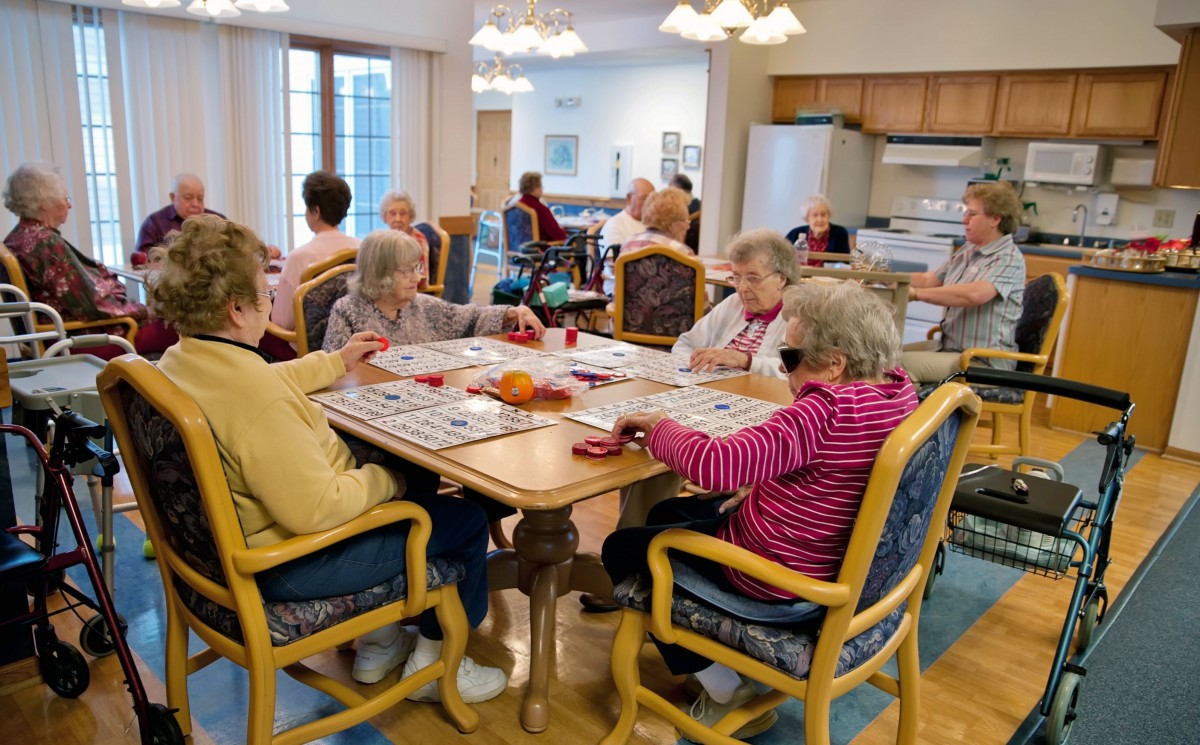 A group of elderly individuals engaged in a social activity at a community center.