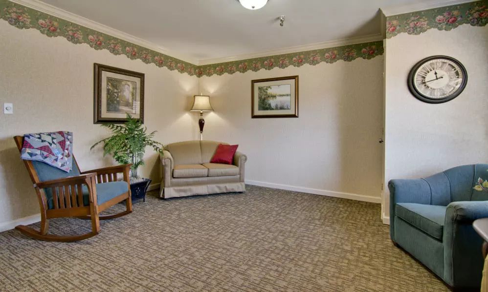 A cozy living room with a sofa, armchair, and decorative elements.