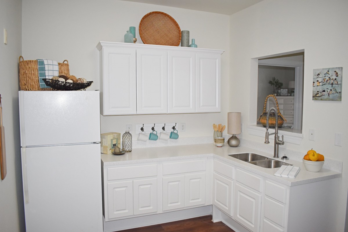 A modern kitchen with white cabinets and minimalist decor.