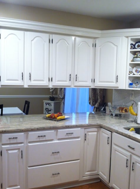 A modern kitchen with white cabinetry and a clean countertop.