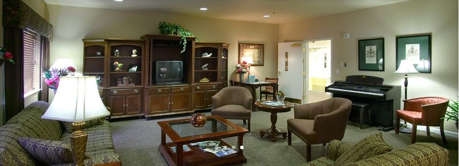 A cozy living room with comfortable seating, a wooden cabinet holding a television, and a coffee table.