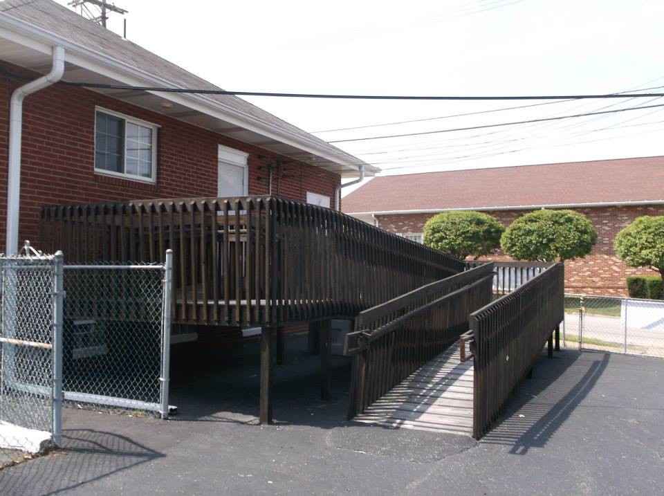 An outdoor wheelchair ramp providing accessibility to a brick building.