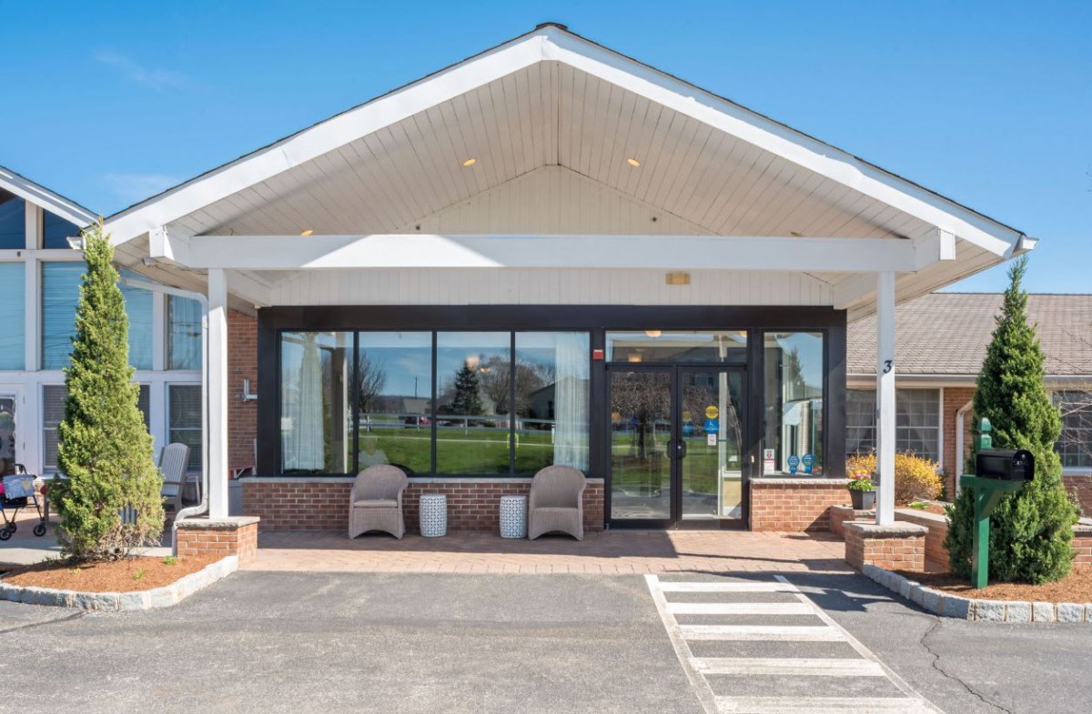 A modern building entrance with glass doors and seating area.