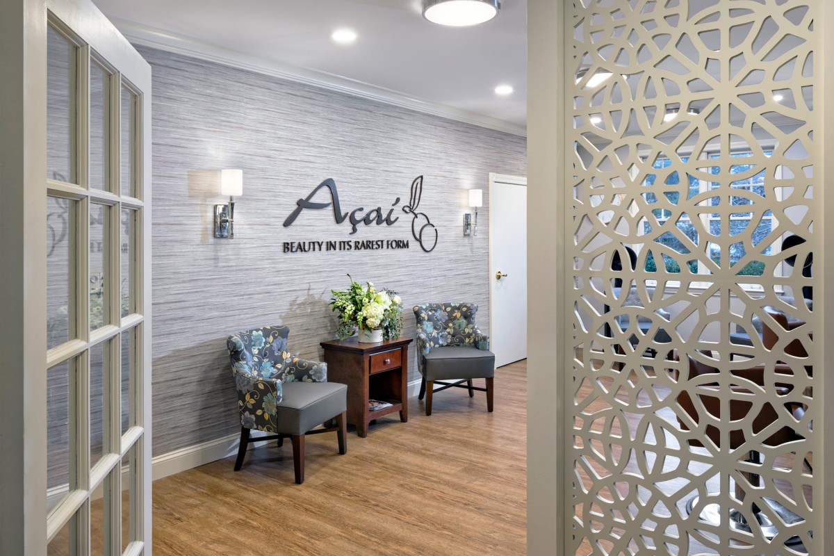 A welcoming reception area featuring comfortable chairs, a floral arrangement, and stylish wall decor.