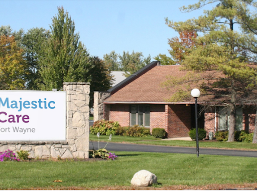 A welcoming entrance to a facility, featuring well-maintained landscaping and a clear sign.