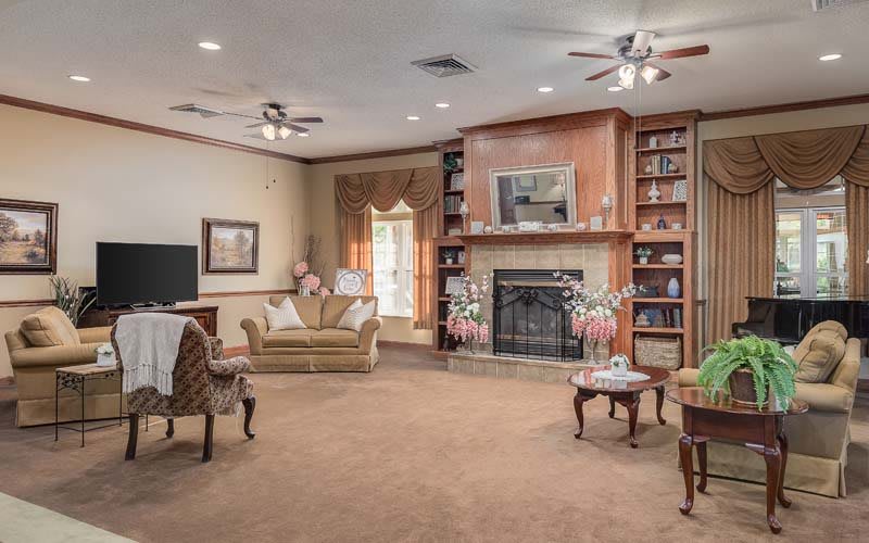 A cozy living room with a fireplace, bookshelves, and comfortable seating.