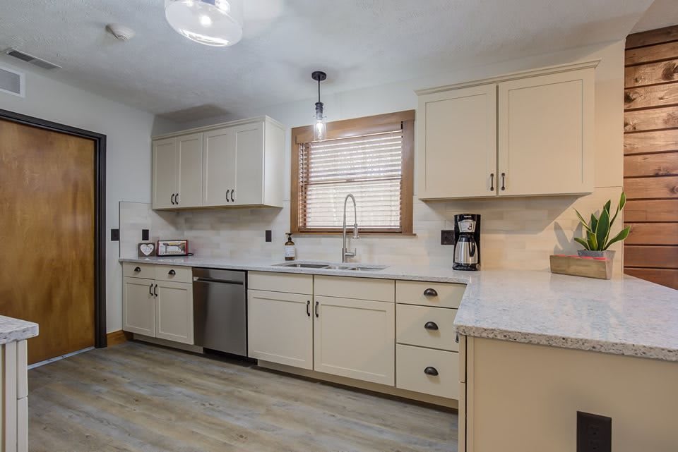 A modern kitchen with light-colored cabinets, stainless steel appliances, and a spacious countertop.