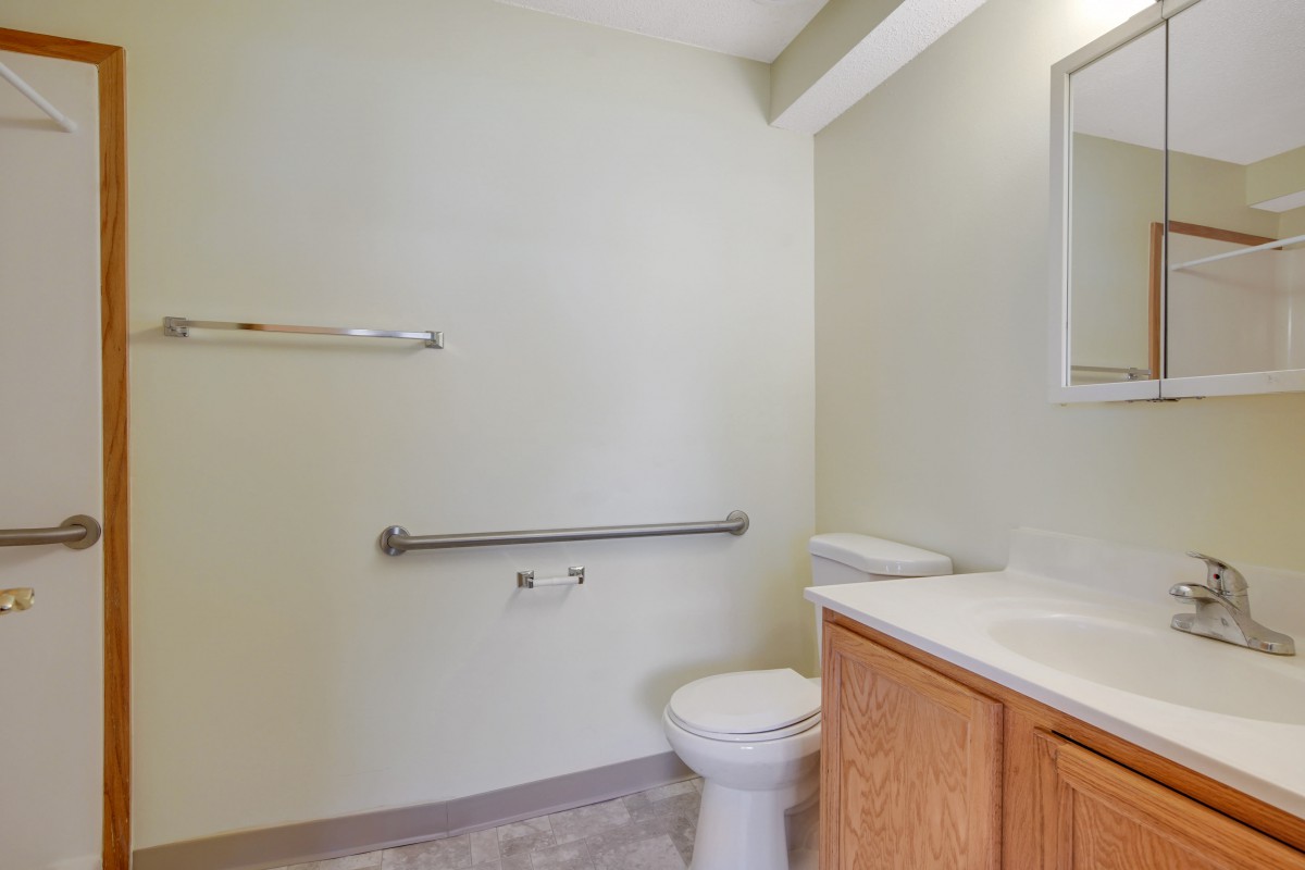 A simple bathroom with a toilet, sink, and mirror.