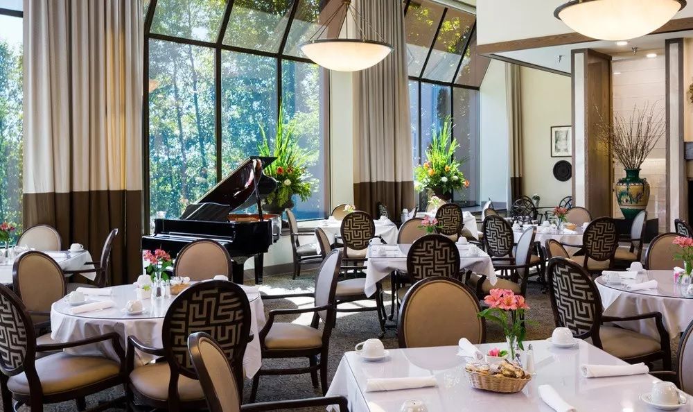 Elegant restaurant dining area with a grand piano and beautifully arranged tables.