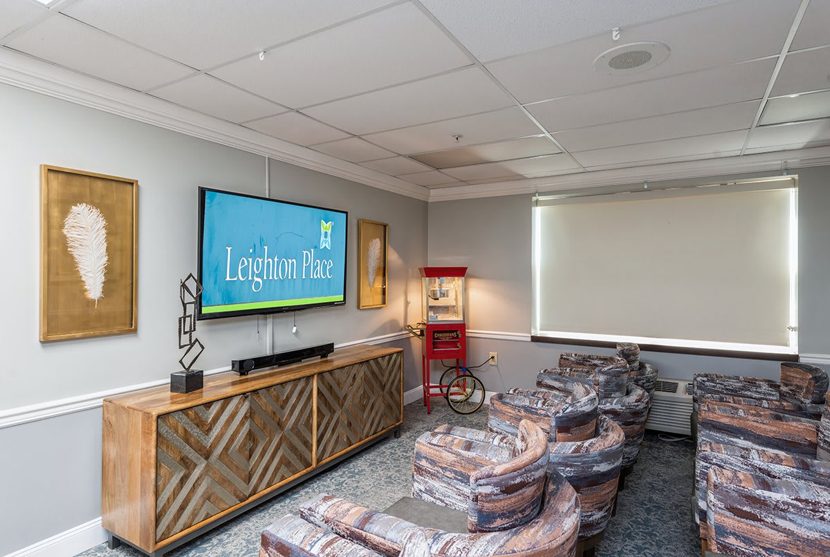 A cozy home theater room with comfortable seating and a popcorn machine.