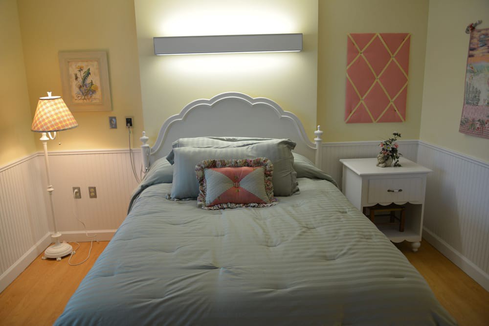 Cozy bedroom with decorative pillows and wall art.
