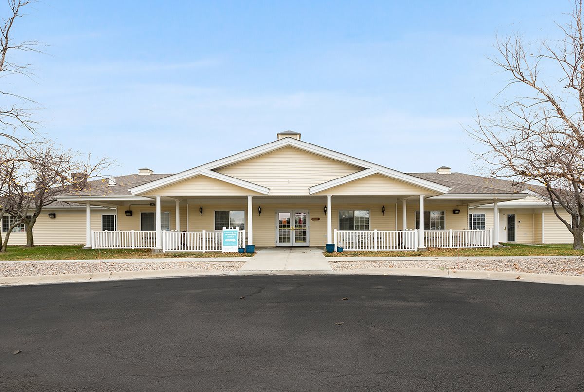 A front view of a large residential building with a porch and entrance.