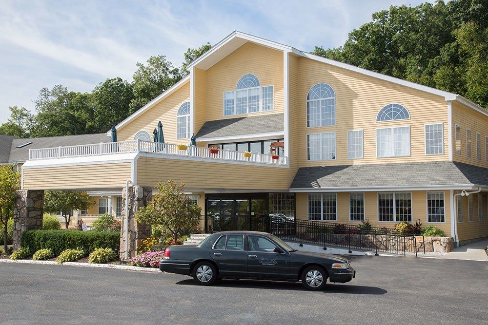 A hotel exterior with a car parked in front.