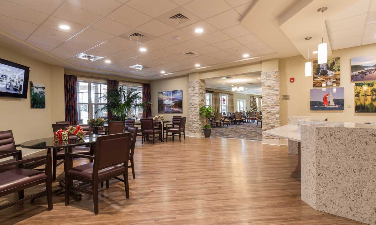 Spacious and well-lit dining area with elegant furniture and wooden flooring.