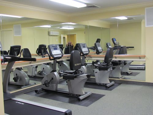 A fitness center with multiple stationary bikes lined up for exercise.