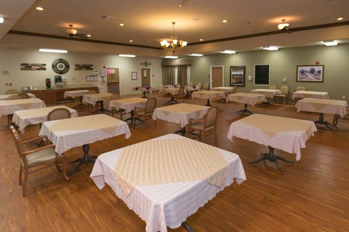 A spacious dining area with neatly arranged tables and chairs, adorned with white tablecloths.
