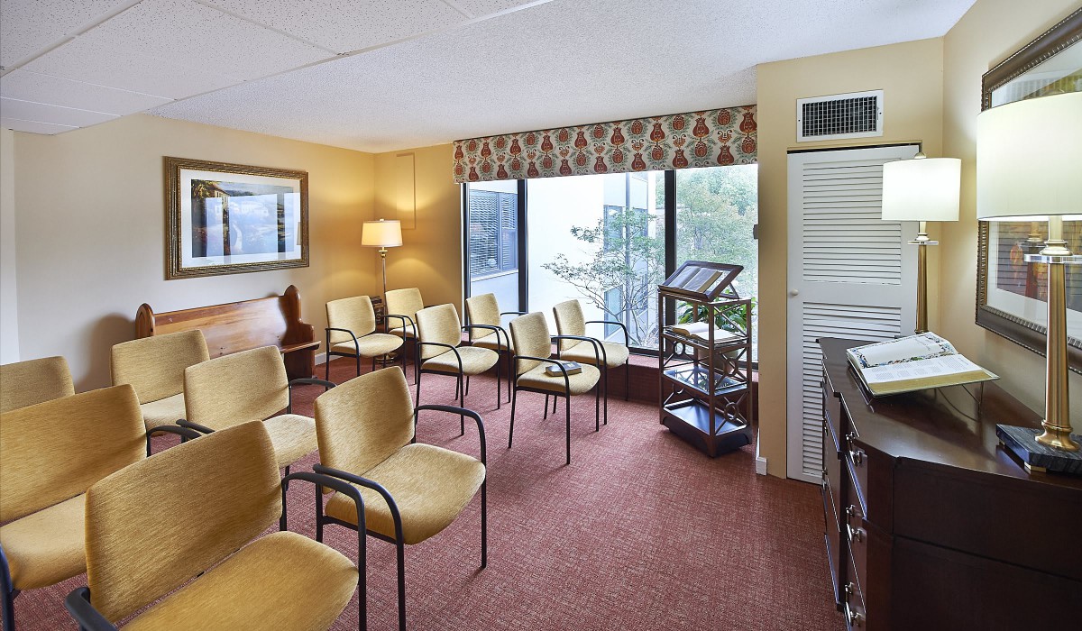 A well-lit waiting room with arranged chairs, large windows, and a warm atmosphere.