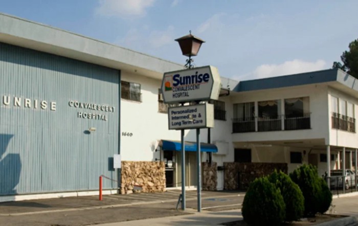 Exterior view of a motel with a prominent sign for Sunrise Inn.