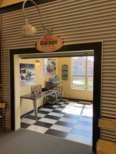 A view into a workshop space featuring a checkered floor and a welcoming sign.
