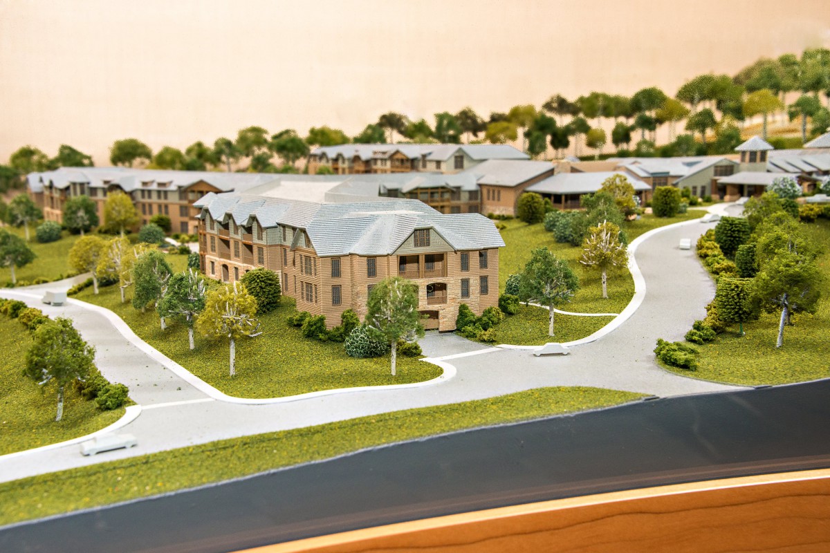 A detailed architectural model depicting a residential area with multiple buildings, roads, and surrounding greenery.