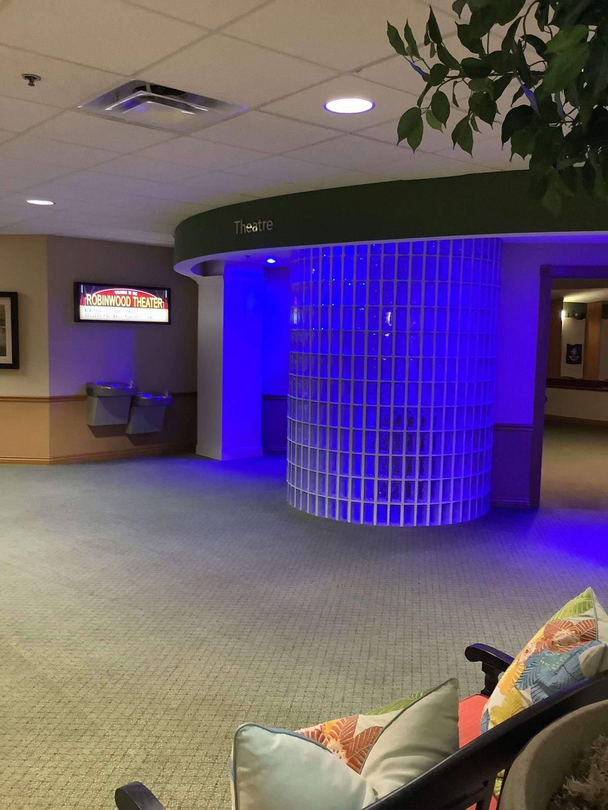 A modern lobby area with blue accent lighting and seating.