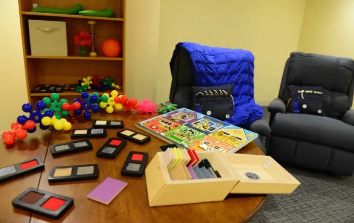 A therapy room equipped with sensory toys, educational puzzles, and relaxation chairs for children.